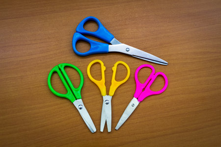 Multi-colored stationery scissors on the surface of the office table.の写真素材