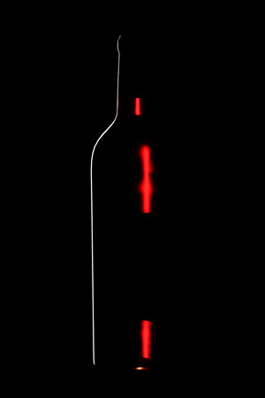 Bottle with red wine on a black background.の写真素材