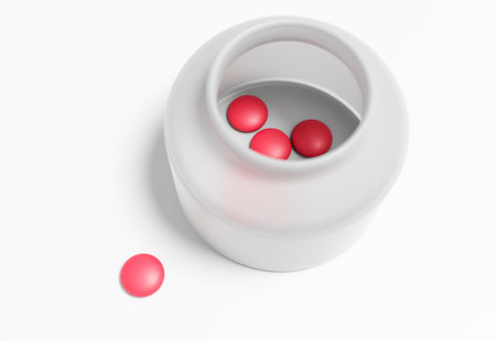 The remains of red oval pills are scattered next to the empty bottle.の写真素材
