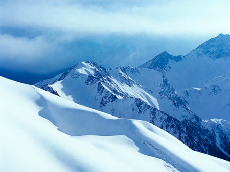 Beautiful landscape of snowy mountain peaks above the clouds.の写真素材