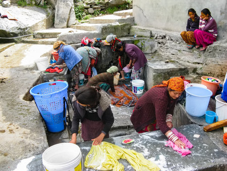 VASISHTA VILLAGE, CITY OF MANALY, STATE HIMACHAL PRADESH, INDIA - APRIL 18, 2014: Women wash clothes at the source. in a small village in the Himalayas in the north of the state Himachal Pradesh.のeditorial素材