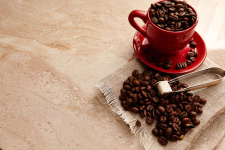 red cup of coffee on marble table with sugar .の写真素材