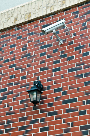Security camera and flashlight on the wall of the houseの写真素材