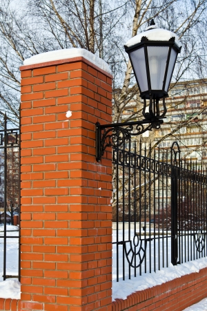 Beautiful street lamp at the red-brick wall under the snowの写真素材