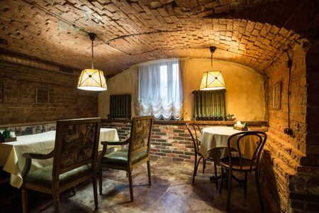 Old bunker room - red brick room, semicircular ceiling, 17th century. Antique furniture - chairs and tableの写真素材