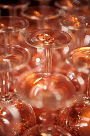 Wedding rings on the glasses. Bokeh, sparkle, play of light.の写真素材