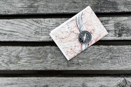 Compass and map on a beautiful wooden surface. Top view