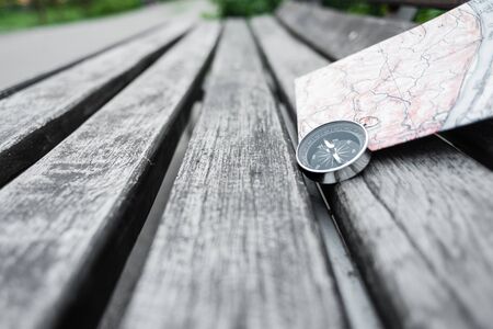 Compass and map on a beautiful wooden surface. Top view