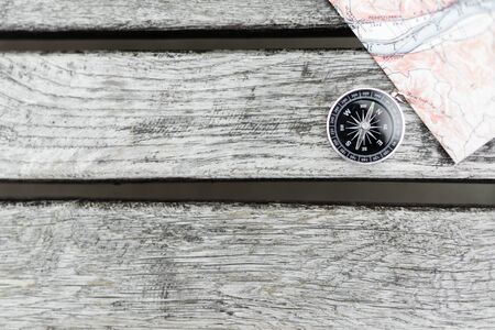 Compass and map on a beautiful wooden surface. Top view