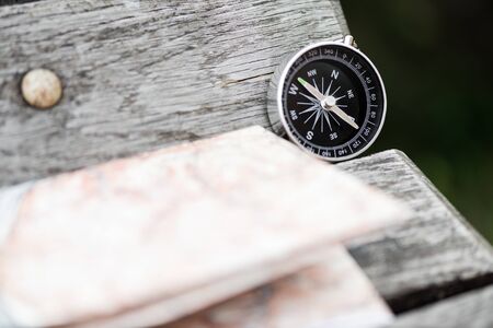 Compass and map on a beautiful wooden surface. Top view