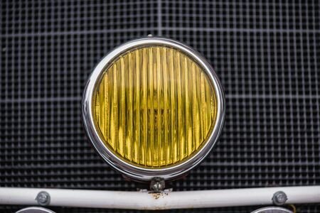 A yellow retro car headlightの写真素材
