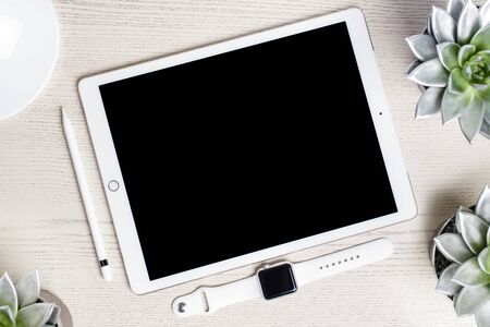 White tablet on white wooden board