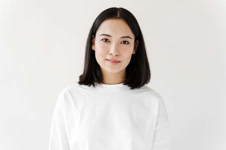 Young brunette woman over isolated white background. Girl looking at the camera