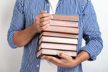 Closeup man holding books in his hands. Back to school.- Imageの写真素材