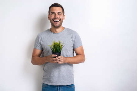 Happy man holds fresh grass pot in his hands .Concept World Environment Dayの写真素材
