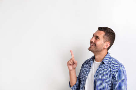 Man pointing his index finger up on empty copy space in the studio . - Imageの写真素材