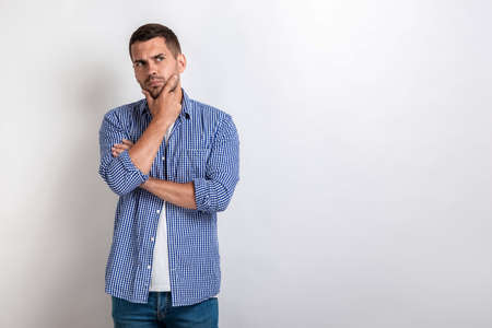 Handsome man standing with thinking look.- Imageの写真素材