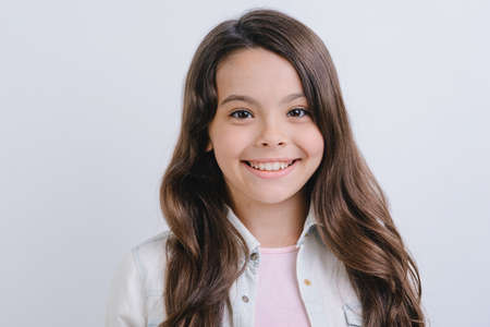 Closeup portrait of a happy girl over white studio background- Imageの写真素材