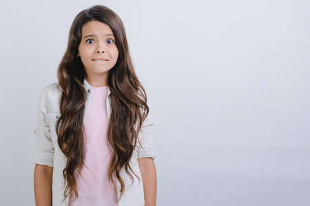 Studio portrait of scared little girl looks unhappy.- Imageの写真素材