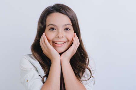 Closeup portrait of a happy little girl kid over white studio background- Imageの写真素材