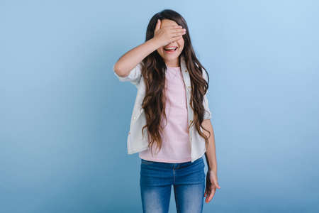 Portrait of a funny girl with long hair covering her eyes with her hand.- Imageの写真素材