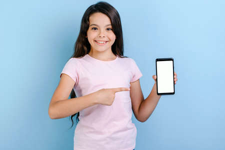 Smiling girl holding a smartphone and pointing to screen - Mockup image of white empty blank screen of phoneの写真素材