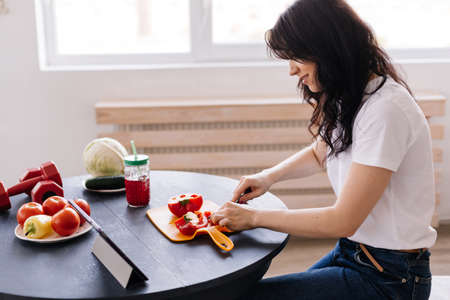 Attractive young woman preparing a delicious, wholesome lunchの写真素材