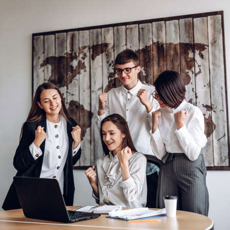A group of business people working in an office at a joint meeting make a winning gestureの写真素材