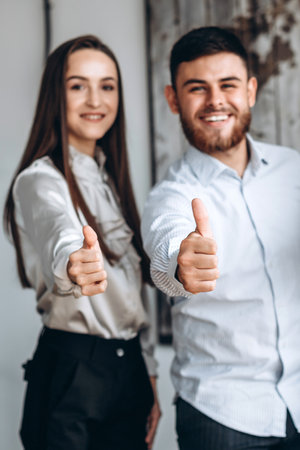Great job! Attracktive business lady and business man showing thumb upの写真素材