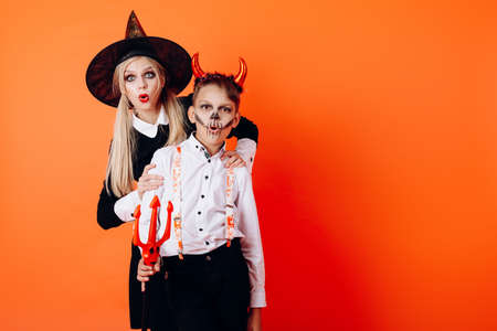 Woman and boy in Devil masquerade makeup showing wonder emotion. Halloween conceptの写真素材
