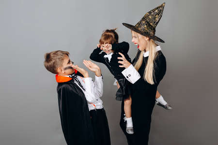 Family in fancy dress showing scary gesture.- Halloween conceptの写真素材