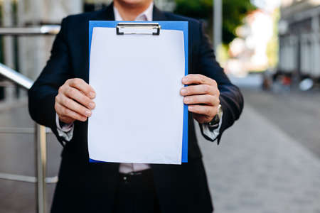 Closeup white empty blank mockup of paper sheet in  male hands  - Copy spaceの写真素材