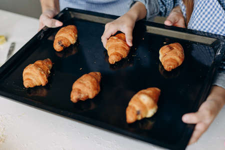 Closeup female hand take a  croissant- Imageの写真素材