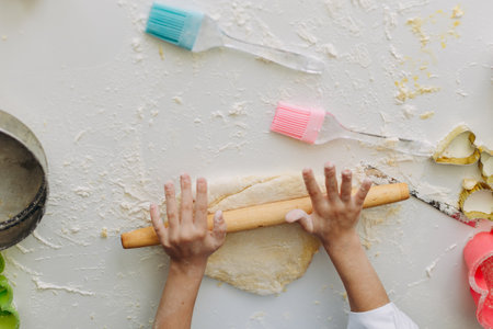 Closeup female hands daughter and mother are stir the dough .Top view- Imageの写真素材
