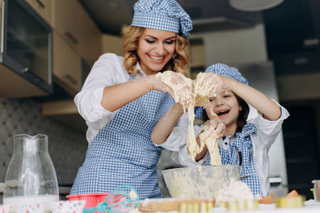 Daughter and mother are stir the dough and have a funny time .Family concept- Imageの写真素材