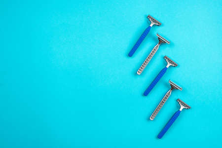 Blue disposable razors isolated on blue backgroundの写真素材