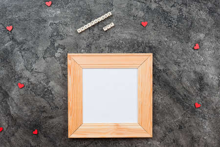 On a dark gray background lies a wooden frame, with space for writing wishes, copy spaceの写真素材