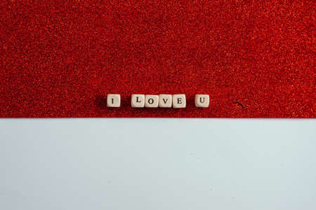 On a shiny red background, the bones are laid out with the phrase: I love you. Concept of Valentine's Day.の写真素材