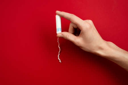 Closeup female hand holding a tampon.  Concept women sanitary protectの写真素材