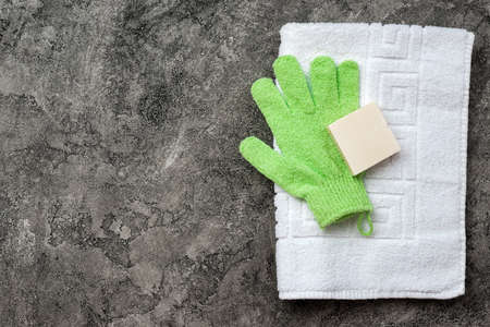 Soap, shower towel, bath mitten on gray, plaster flat lay background with copy space. Hygiene concept.の写真素材