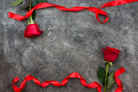 Valentine's Day or other love holiday. On a gray background, red trojans are decorated with red ribbon, top viewの写真素材