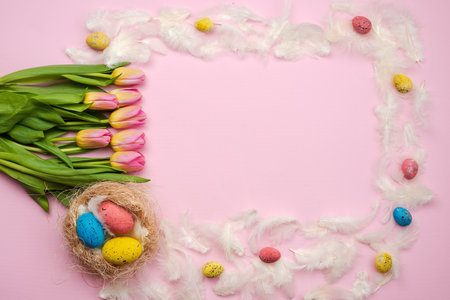 Easter pink background with chocolate, easter eggs, tulips, feathers