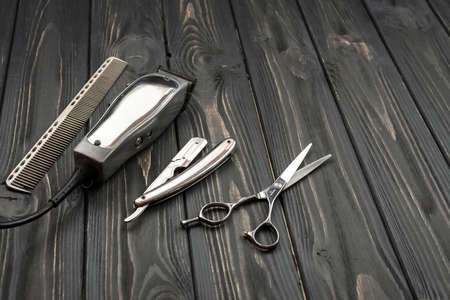 Men's haircut tools on a wooden, dark background.の写真素材