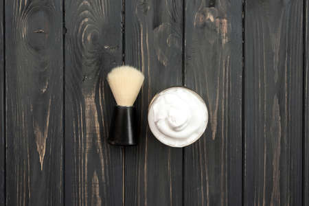 Shaving brush and cream on dark wooden backgroundの写真素材