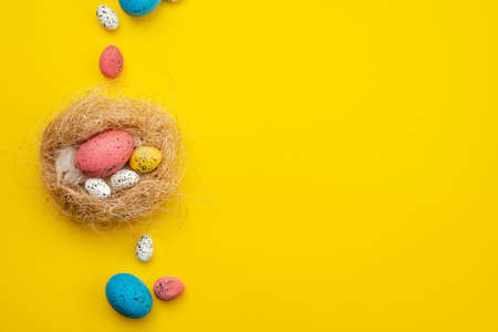 Easter eggs in nest over yellow background. View with copy spaceの写真素材
