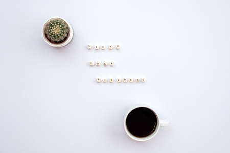 An inscription grove your business on the white desk next a cactus and a cup of coffeeの写真素材