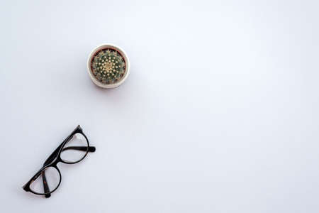 Top view office white  desk with a glasses and cactus. - Copyspaceの写真素材