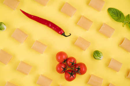 Delicious ingredients for an Italian dish arranged on a yellow background.の写真素材