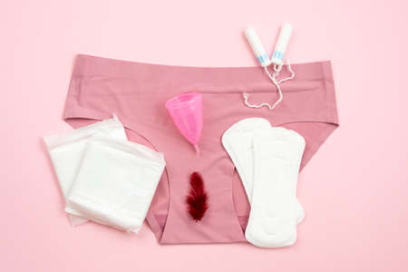 Women's topics. On a pink background, women's shorts, pads, menstrual cup, tampons.の写真素材