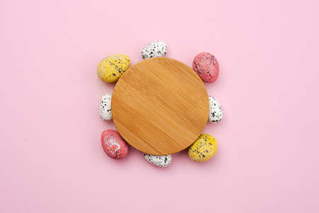 Colorful, easter eggs around wooden stand on yellow backgroundの写真素材